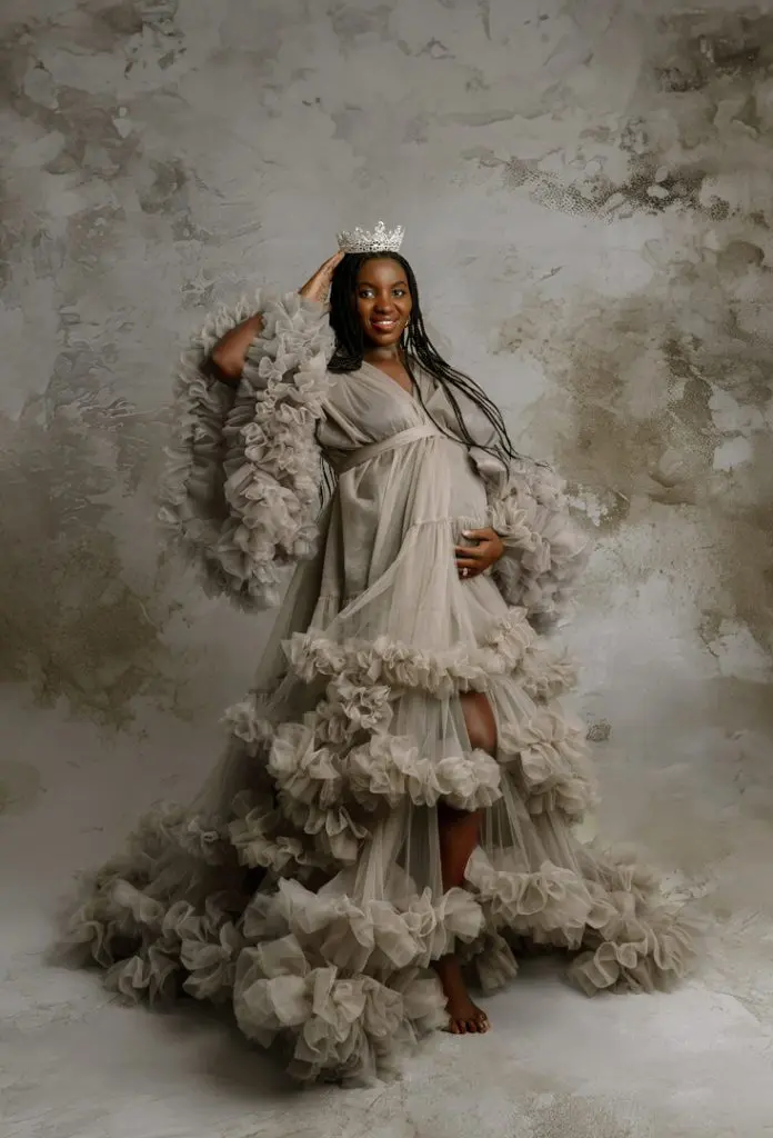 Pregnant woman wearing a color-changed tulle maternity gown in soft beige tones, accessorized with a crown, showcasing maternity photography options in Cedar Falls, Waterloo, and nearby Iowa areas