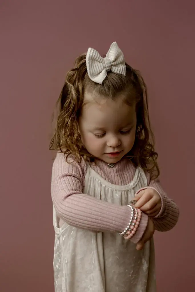 Mabel looking at her bracelets during her mini session in Cedar Falls, Iowa.