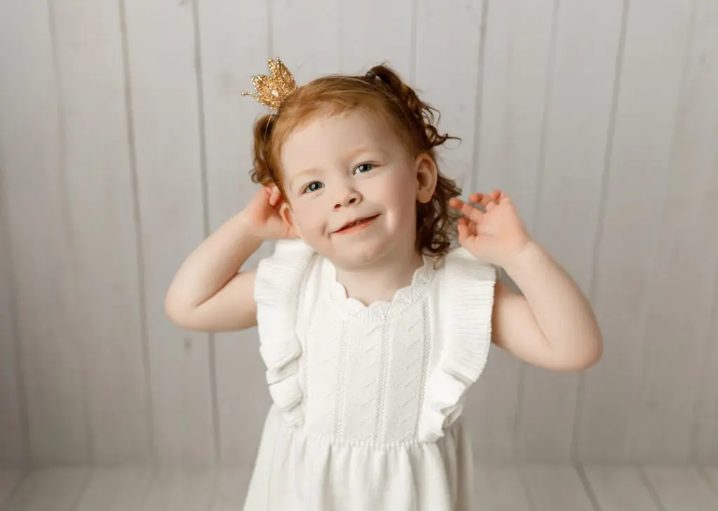Toddler girl wearing crown, sibling portrait during newborn session in Cedar Valley, Iowa.