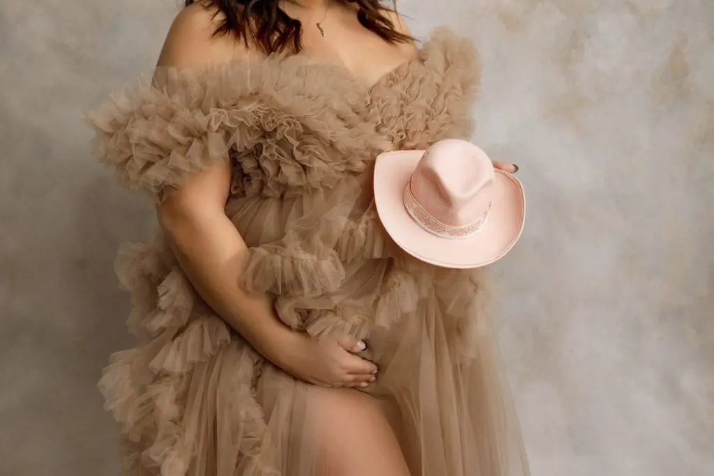 Detail maternity portrait featuring a newborn-sized cowgirl hat in studio session near Janesville, Iowa.