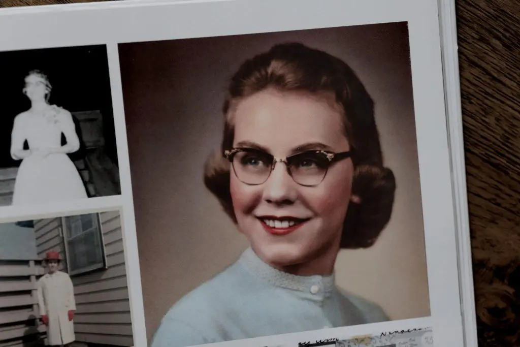 Color portrait of grandmother in glasses and blue sweater from a vintage album.