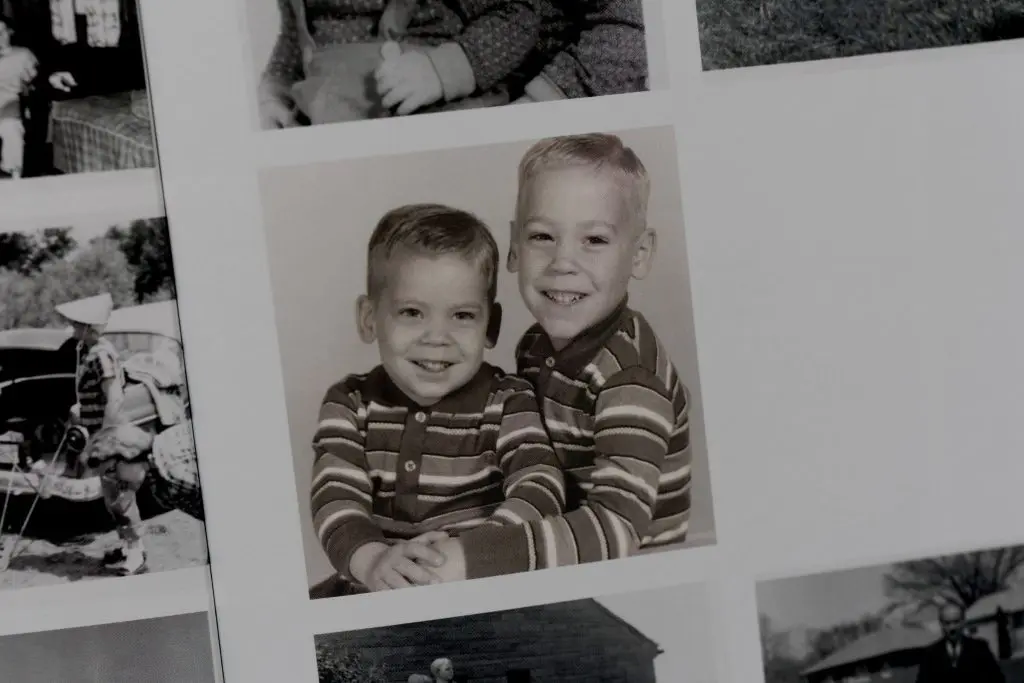 Portrait of two young boys in matching striped shirts from a vintage photo album.