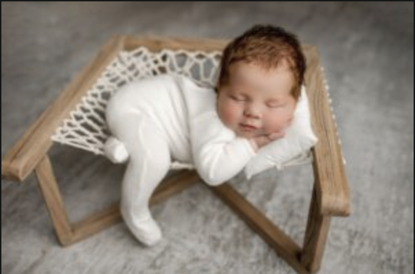 Studio newborn portrait of baby boy in white sleeper on macrame hammock – Iowa photographer
