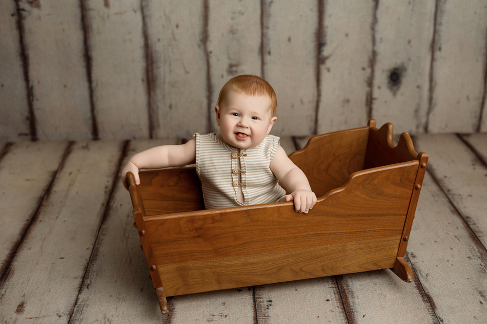 Milestone photo session featuring baby Colter in handmade crib from grandpa.