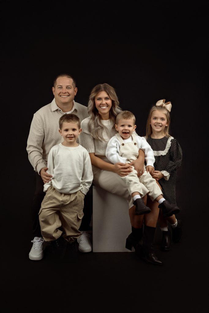 Family smiling together during their indoor studio photography session near Waverly, IA.