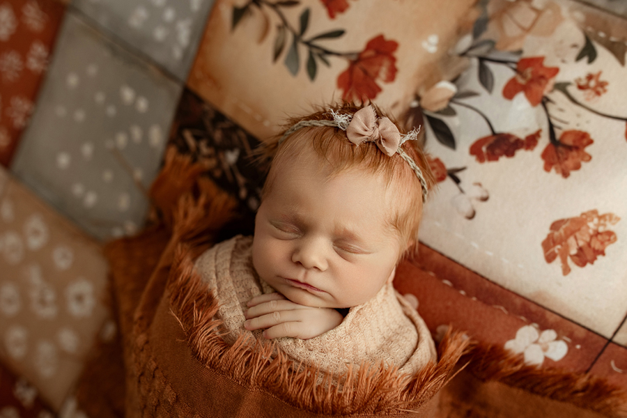 Boho-style newborn photography with patchwork posing fabric, Cedar Falls studio.