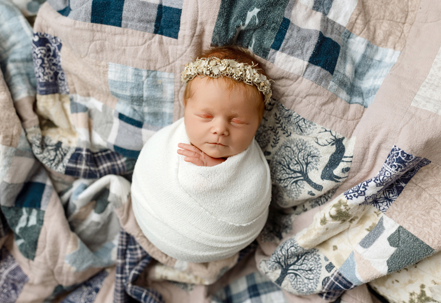 Newborn baby swaddled on family heirloom quilt, posed newborn photo near Grundy Center, Iowa.