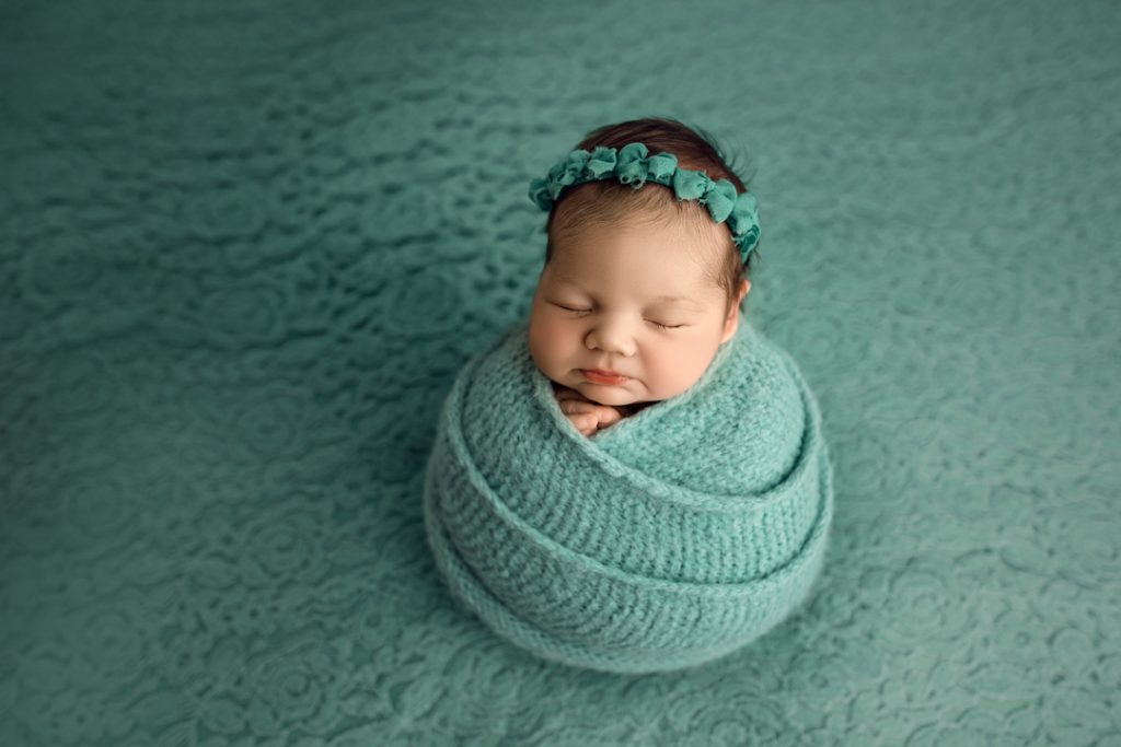 Newborn wrapped in teal swaddle with matching headband during Waterloo newborn session.