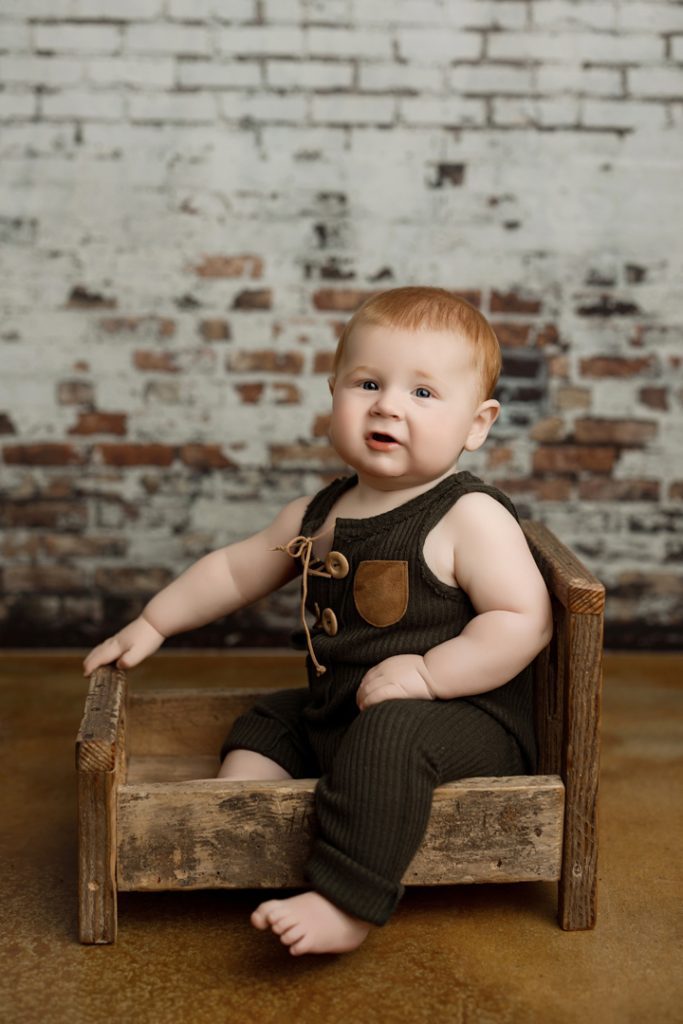 Baby Colter seated during an urban style milestone portrait session in Cedar Falls.