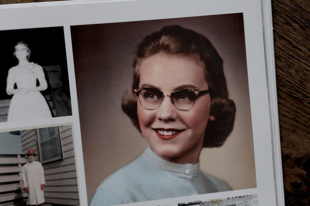 Color portrait of grandmother in glasses and blue sweater from a vintage album.