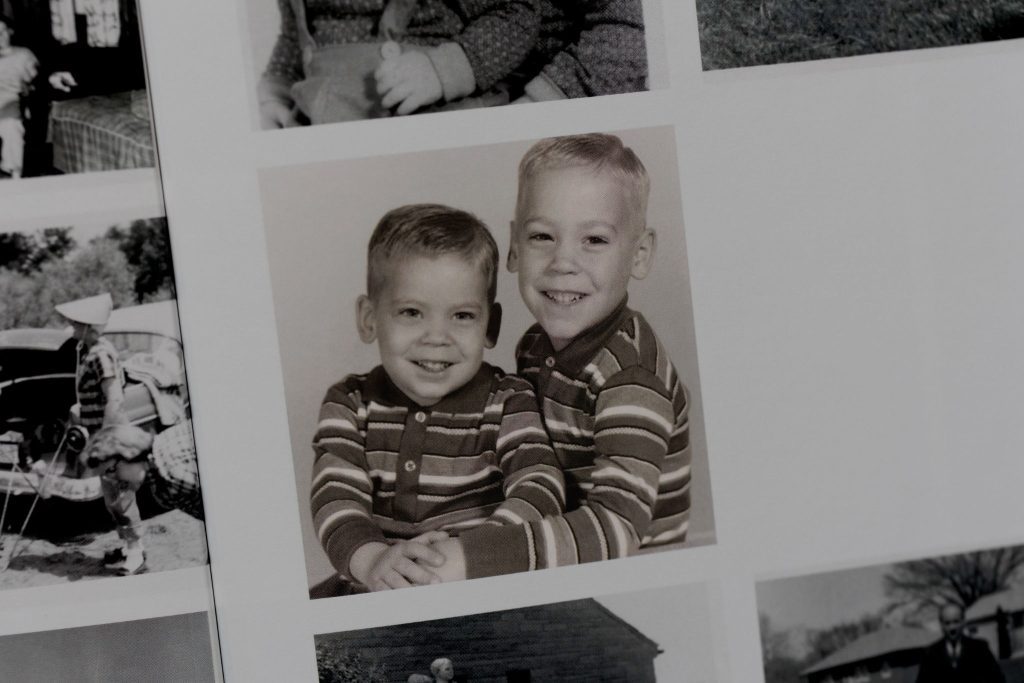 Portrait of two young boys in matching striped shirts from a vintage photo album.