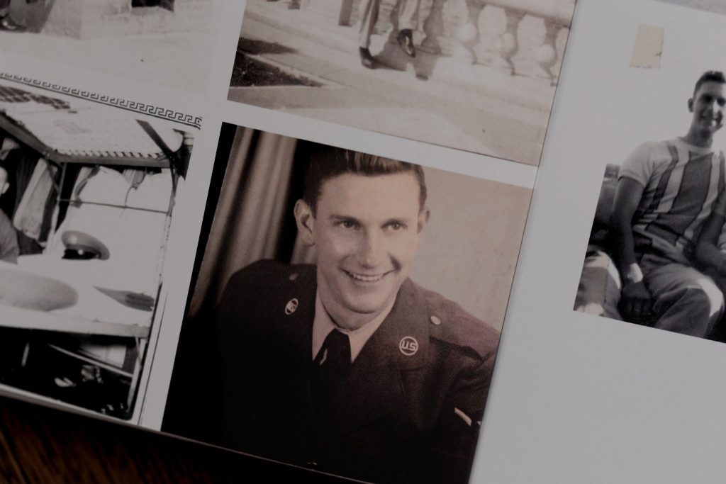 Formal military portrait of a young man in uniform with a confident smile.